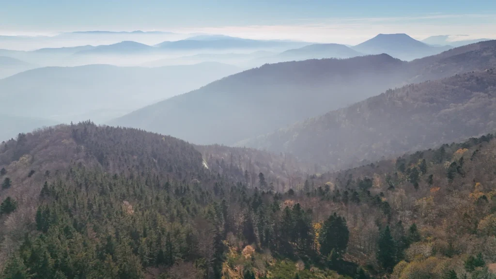 vue sur les sommets des montagnes vosgiennes avec une légère brume qui donne l'impression d'un voile bleu