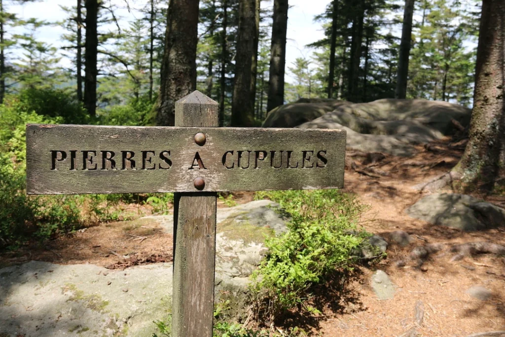 panneau signalétique en bois indiquant les pierres à cupules